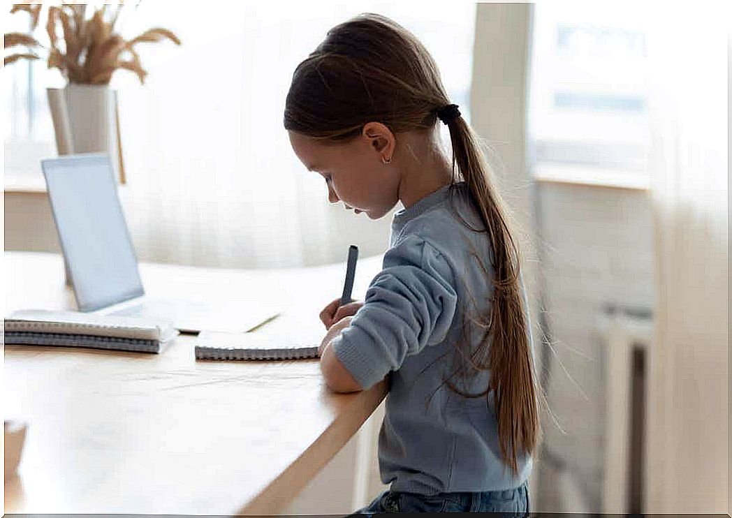 A child sits at a table with a straight back.