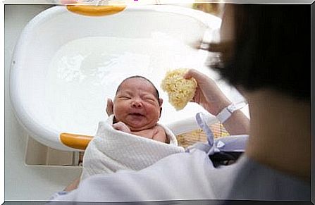 Mother holds baby in towel