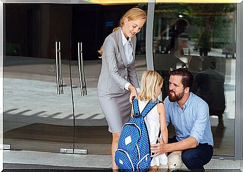 A mother and father saying goodbye to their daughter before school.