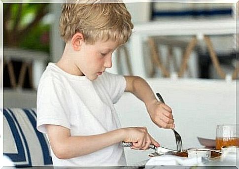 A boy cuts his food