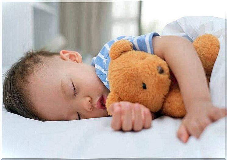 Boy sleeping with his bear