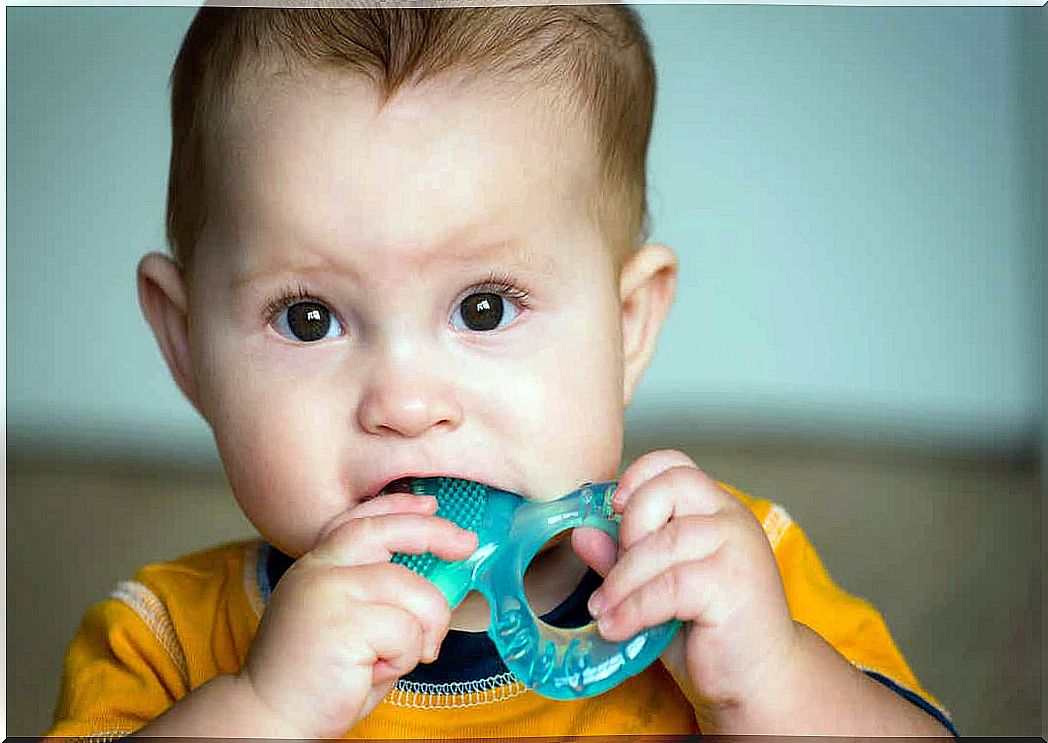 A baby chewing on a teether.