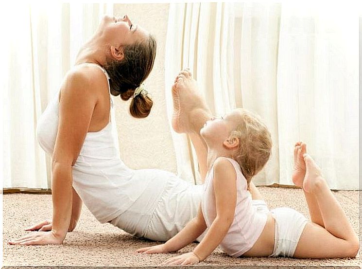 Mother and baby in flexible yoga pose