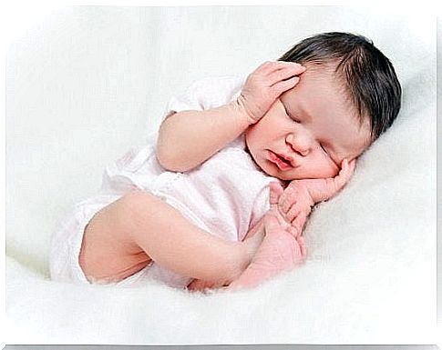 Sleeping baby with hands on head