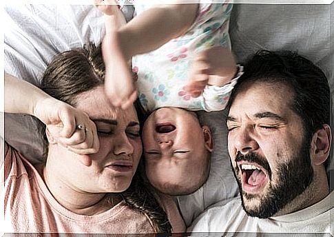 Baby with sleeping problems between mom and dad in bed