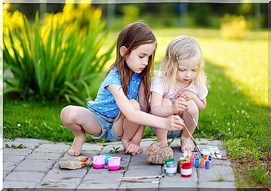 Girls tinkering outside with stones