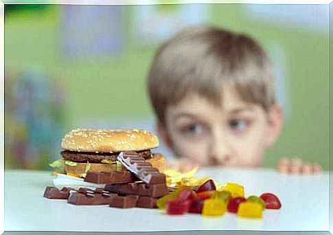 Boy looking at hamburger and candy