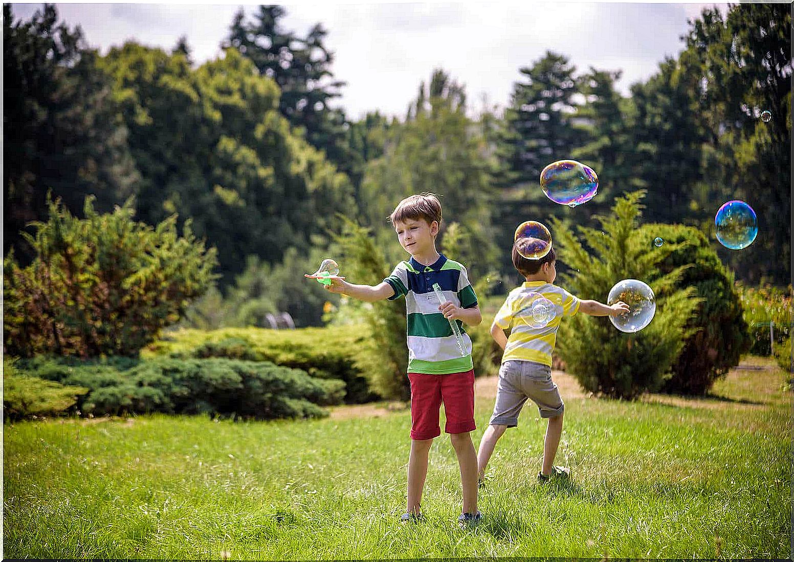 Children blowing bubbles outside.