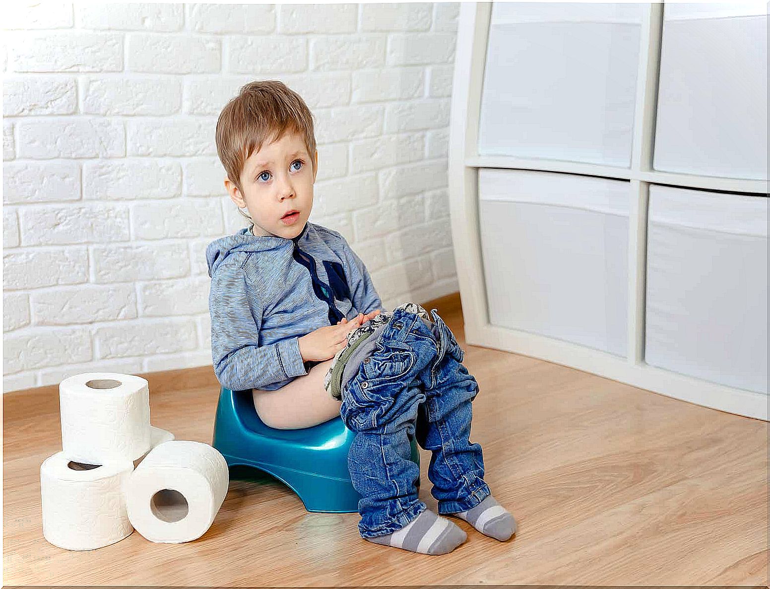 A toddler boy sitting on a potty