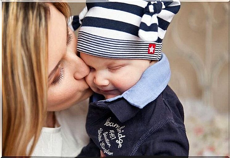 A mother kisses her baby