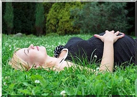 Pregnant woman taking a nap in the grass