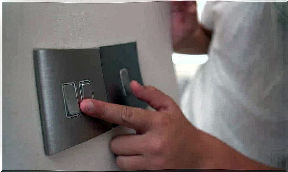 A small child playing with light switches.