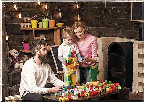 A child plays with LEGO with his parents