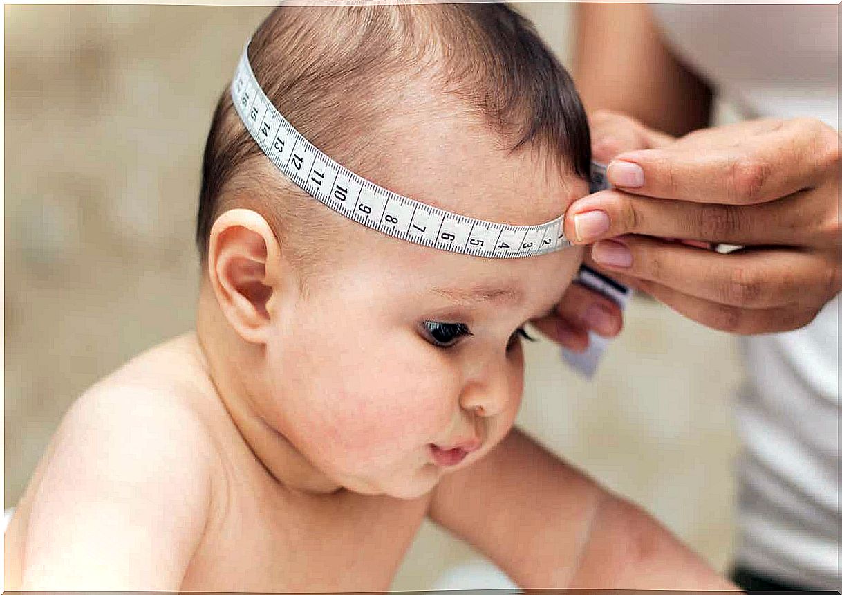 A doctor measuring a baby's head.